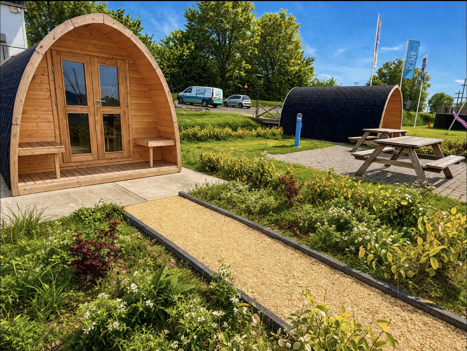 Holz-Camping-Pods mit Picknicktischen auf dem Hafengelände