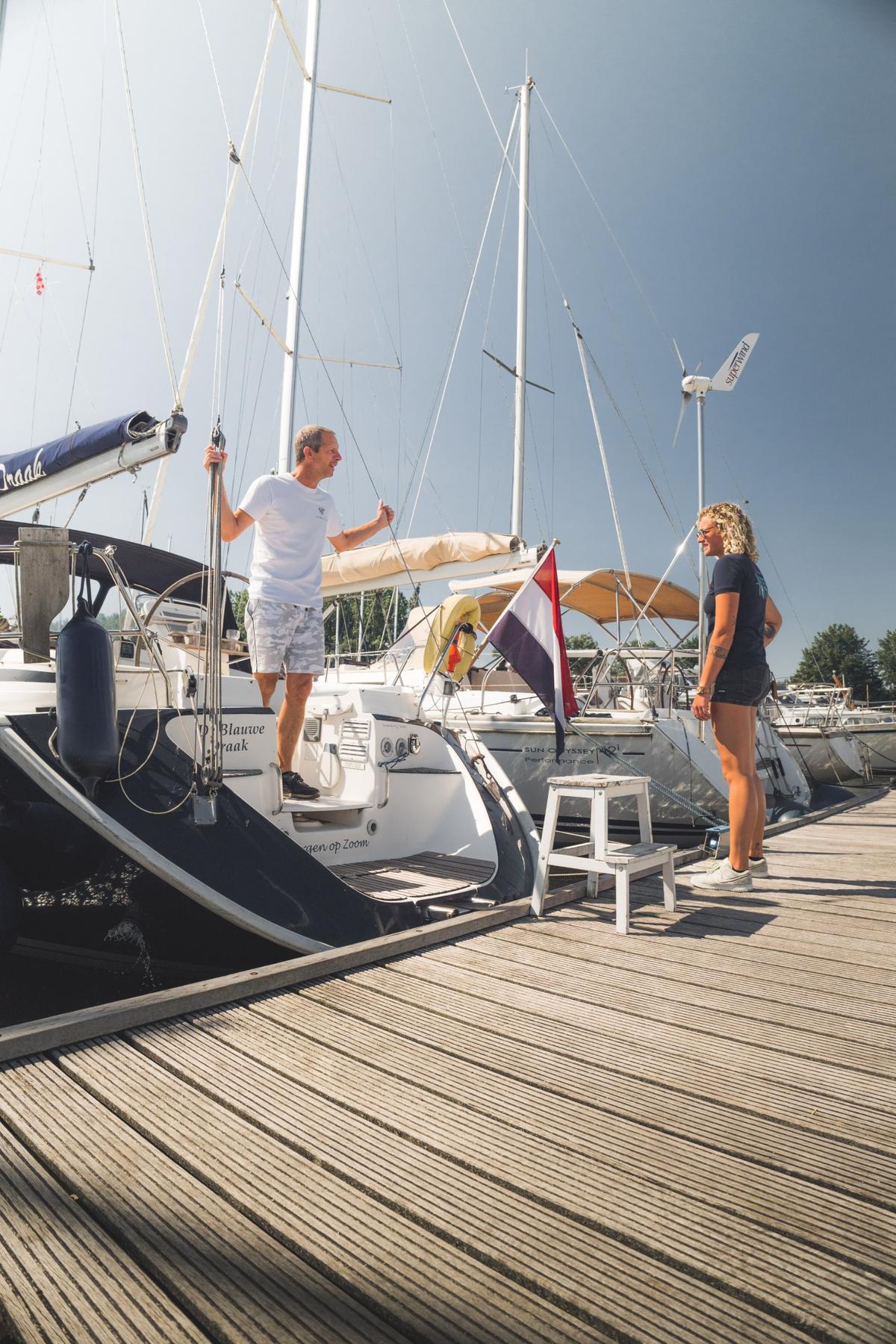 De havenmeester in gesprek met een ligplaatshouder op de steiger