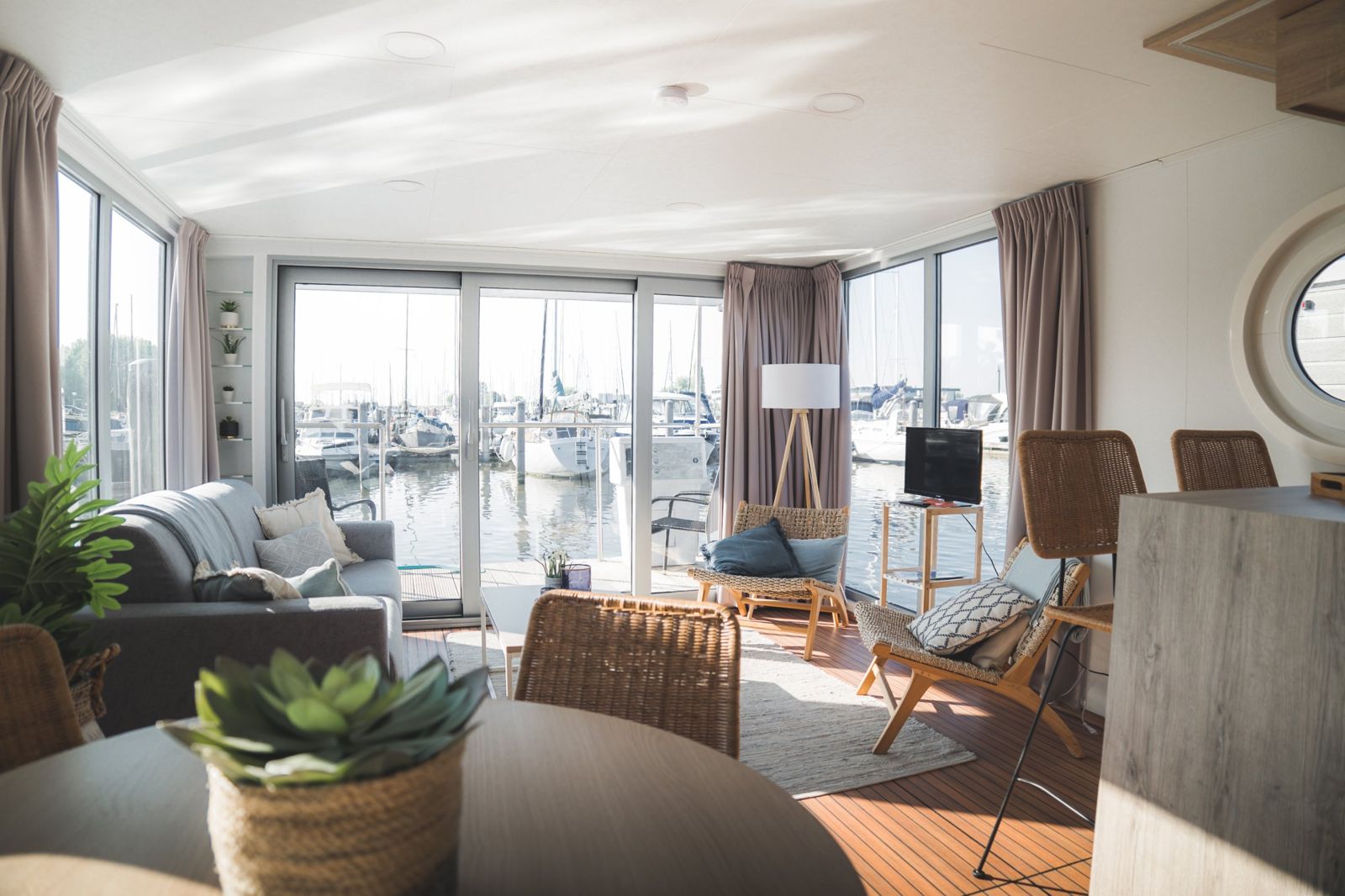 Helles Wohnzimmer des Hausboots mit Blick auf den Hafen
