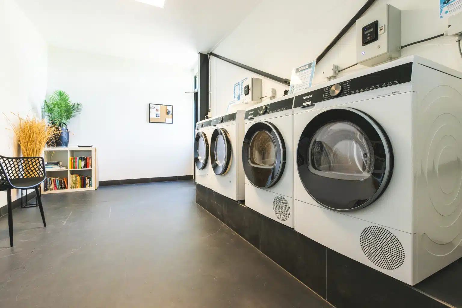 De wasruimte met wasmachines en drogers